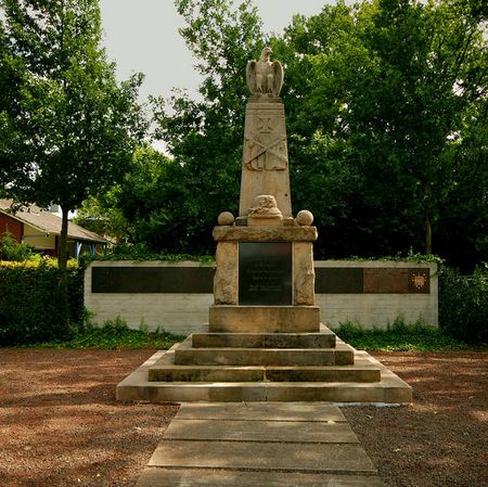 Das Kriegerdenkmal in Neuenhaus neben der Stadtverwaltung. Im Hintergrund befindet sich die rund 8 Meter lange Gedenkstätte der Gefallenen des zweiten Weltkrieges