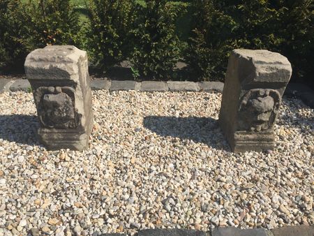 Zwei Steine in die Löwenköpfe gemeißelt sind